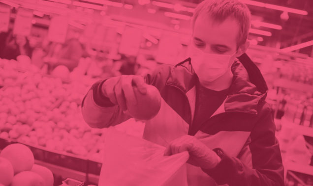 man wearing a mask shopping fruit at a retail store during covid